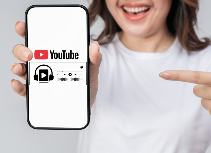 prikaz devojke koja drži telefon u ruci na kojoj stoji logo youtube-a i audio knjige