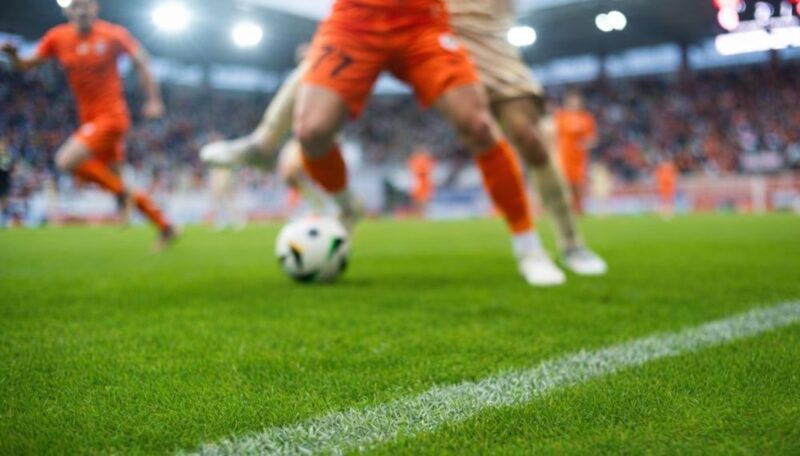 Fudbaleri u akciji na terenu tokom utakmice sa fokusom na loptu i duel igrača